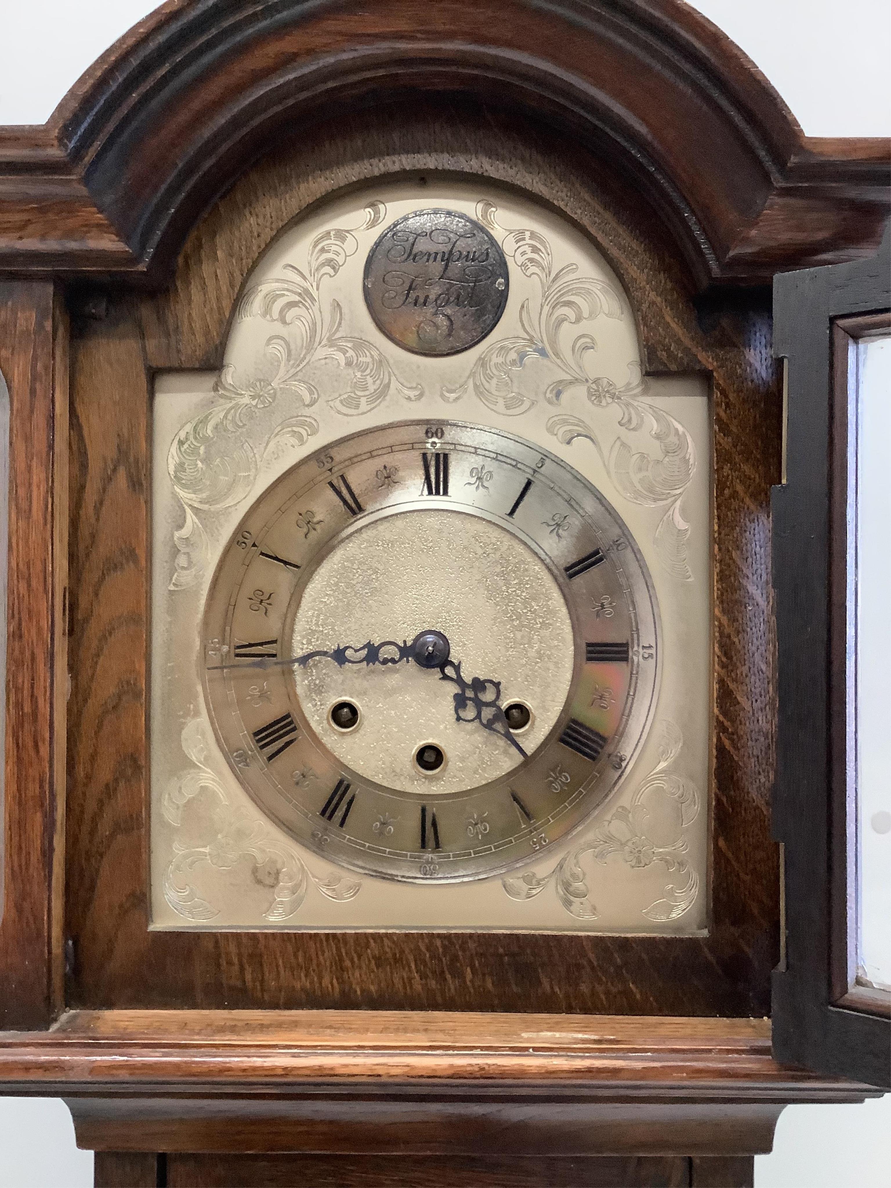 An early 20th century oak chiming grandmother clock with 1932 presentation plaque, height 167cm. Condition - fair to good, movement not tested